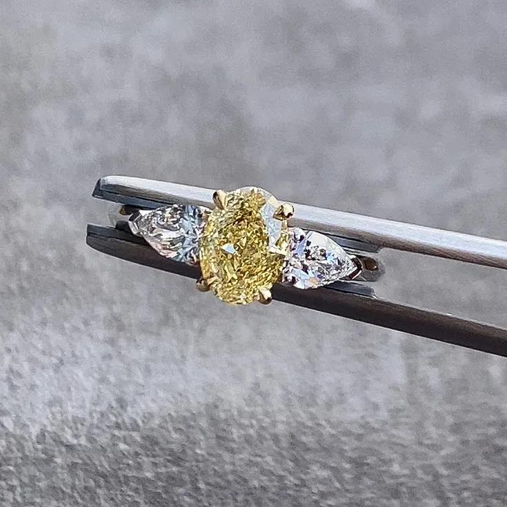 Ring with Oval Yellow Diamond 1.19 ct. and Pear shape Diamonds 0.6 cts.